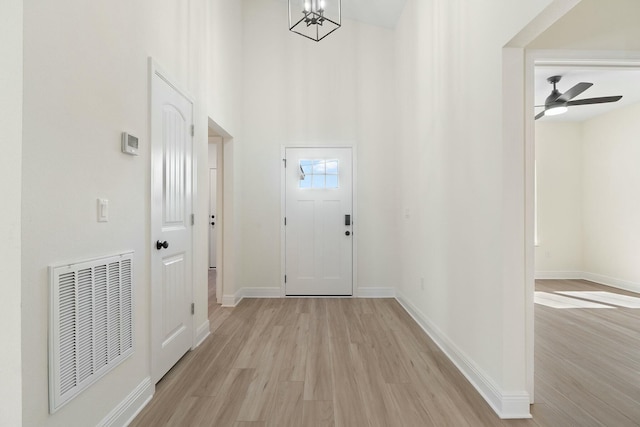 interior space featuring ceiling fan with notable chandelier and light hardwood / wood-style floors