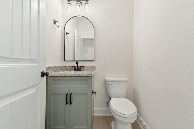 bathroom with vanity, hardwood / wood-style flooring, and toilet