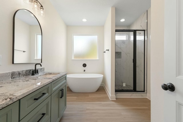 bathroom featuring hardwood / wood-style floors, vanity, and separate shower and tub