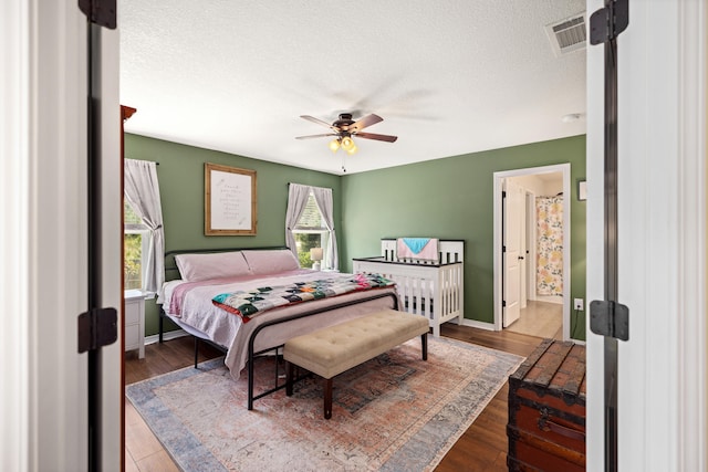 bedroom with hardwood / wood-style flooring, ceiling fan, and a textured ceiling