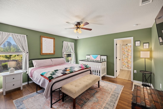 bedroom with ceiling fan, dark wood-type flooring, and a textured ceiling