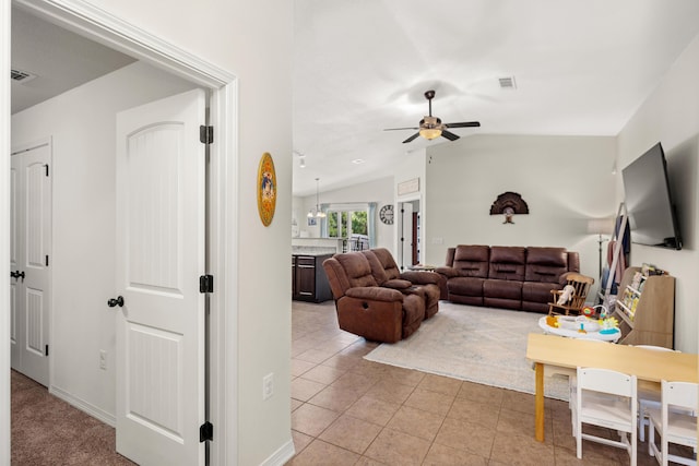 tiled living room with ceiling fan and vaulted ceiling