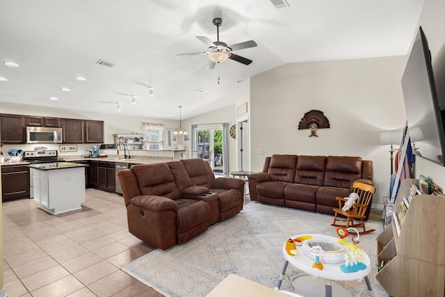 living room featuring lofted ceiling, light tile patterned floors, sink, and ceiling fan