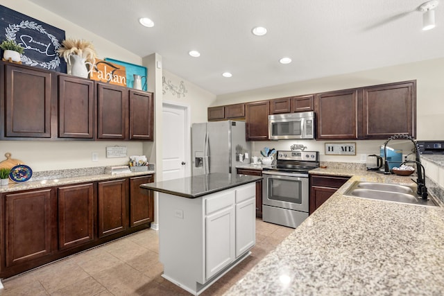 kitchen with dark brown cabinetry, sink, light tile patterned floors, appliances with stainless steel finishes, and a kitchen island