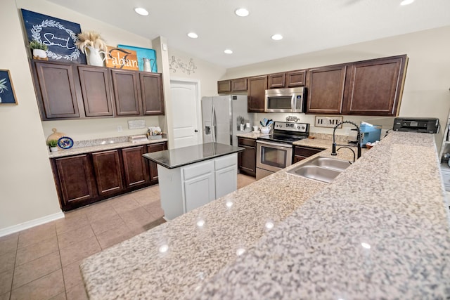 kitchen with sink, a center island, light tile patterned floors, dark brown cabinetry, and stainless steel appliances