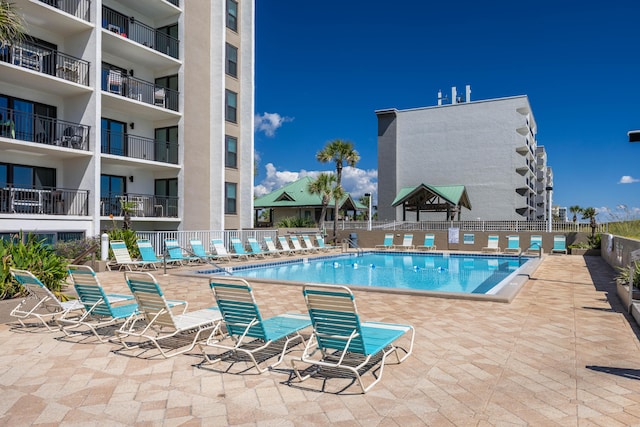 community pool featuring fence and a patio area