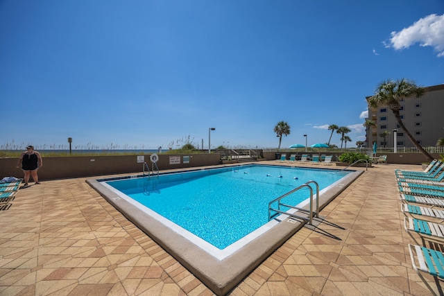 community pool featuring fence and a patio area