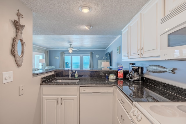 kitchen featuring dark stone counters, sink, white cabinets, white appliances, and ceiling fan