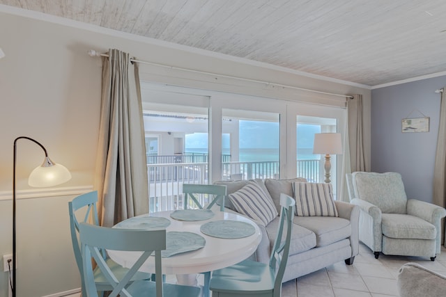 tiled dining space with wood ceiling, a water view, and crown molding