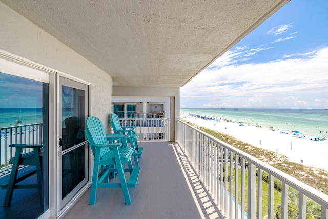 balcony featuring a water view and a beach view