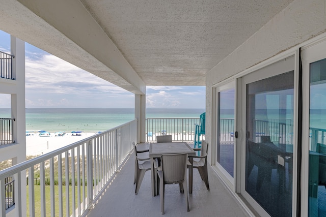 balcony featuring a water view and a beach view