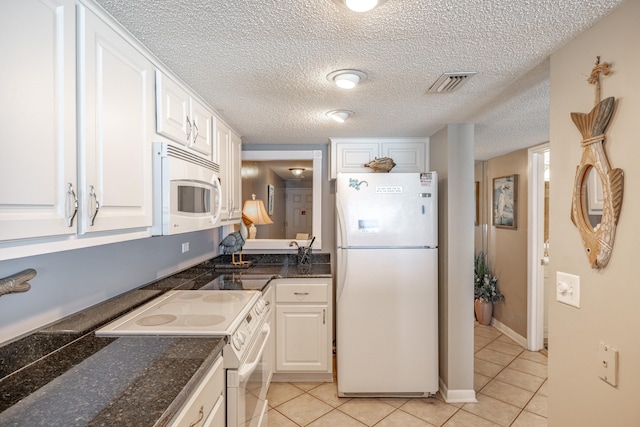 kitchen featuring white cabinets, white appliances, a textured ceiling, and light tile patterned flooring