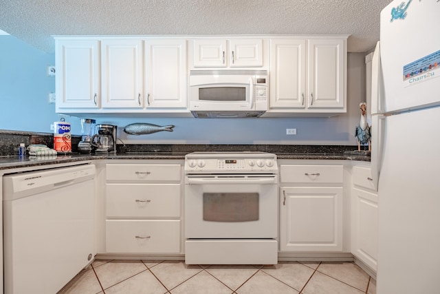 kitchen with white appliances, a textured ceiling, white cabinetry, and light tile patterned flooring