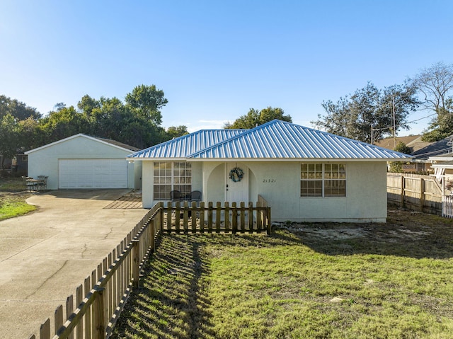 view of front of property with a garage, a front lawn, and an outbuilding