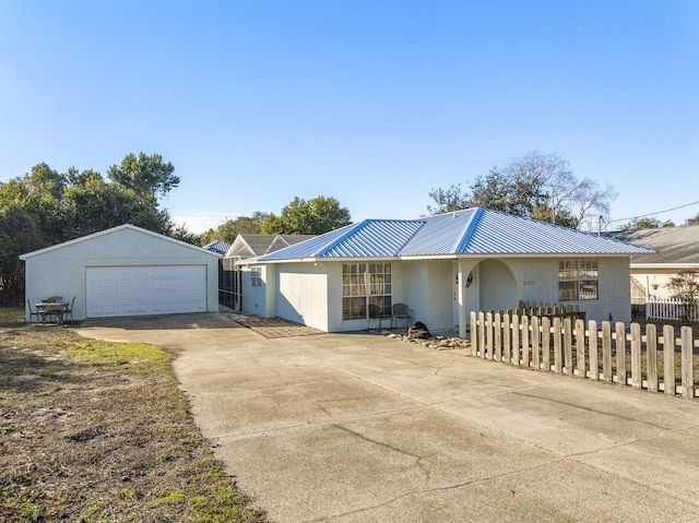 ranch-style home with a garage and an outbuilding