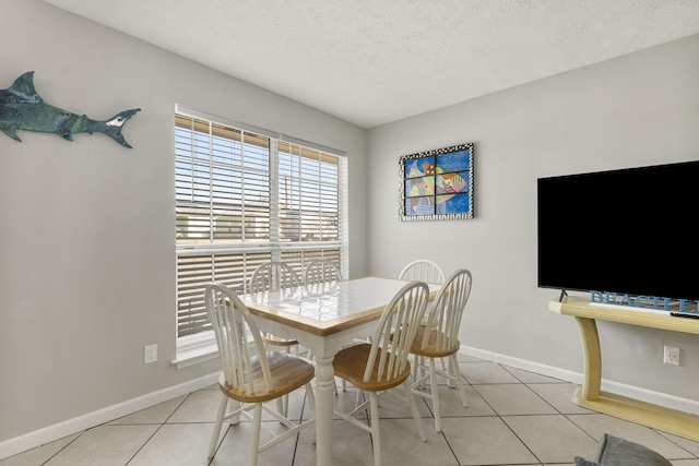 tiled dining space with a textured ceiling