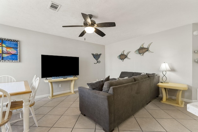 tiled living room featuring ceiling fan and a textured ceiling