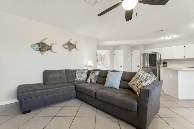 tiled living room with a textured ceiling and ceiling fan