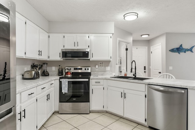 kitchen with white cabinetry, a textured ceiling, appliances with stainless steel finishes, and sink