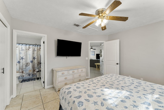 bedroom featuring a textured ceiling, light tile patterned flooring, ceiling fan, and ensuite bathroom