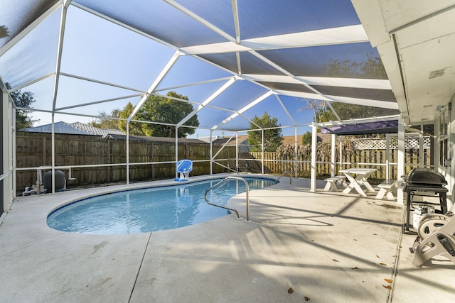 view of pool featuring a grill, glass enclosure, and a patio