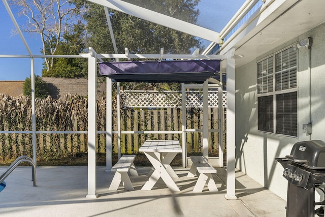 view of patio featuring glass enclosure and area for grilling