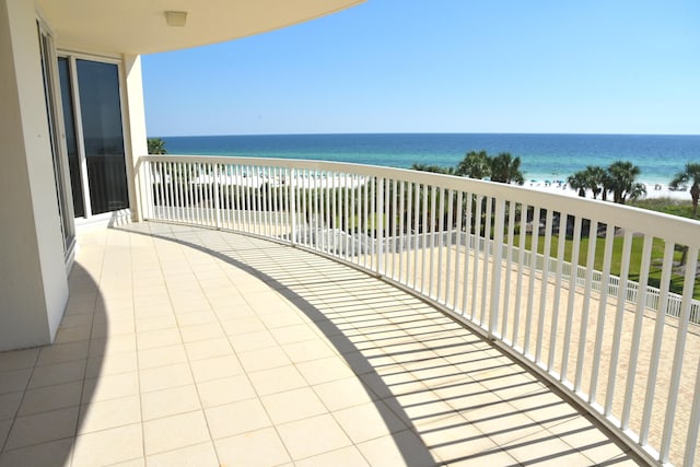 balcony featuring a water view and a beach view