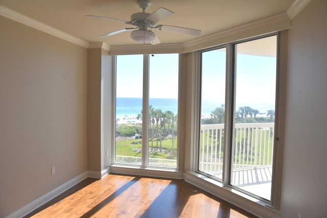 interior space with a water view, wood-type flooring, crown molding, and ceiling fan