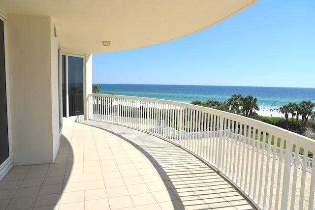 balcony featuring a water view and a beach view