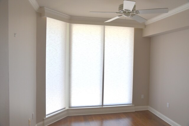 spare room with ceiling fan, crown molding, and dark wood-type flooring