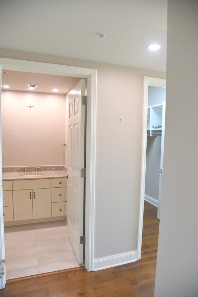 hall with light wood-type flooring and sink