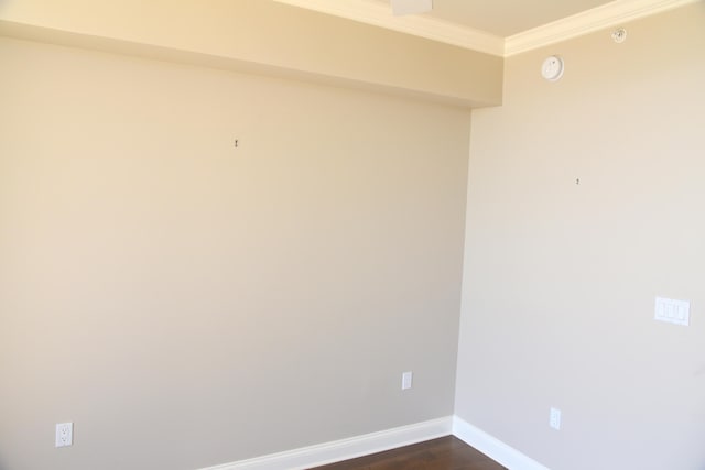 empty room with crown molding and dark wood-type flooring