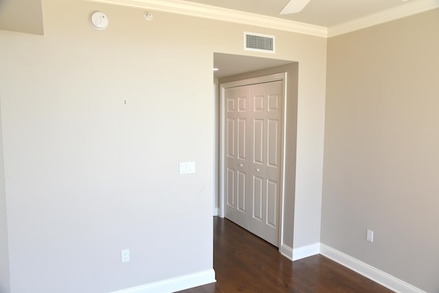 spare room with dark wood-type flooring and ornamental molding