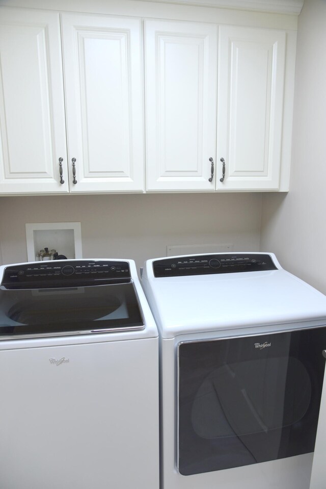 washroom with separate washer and dryer and cabinets