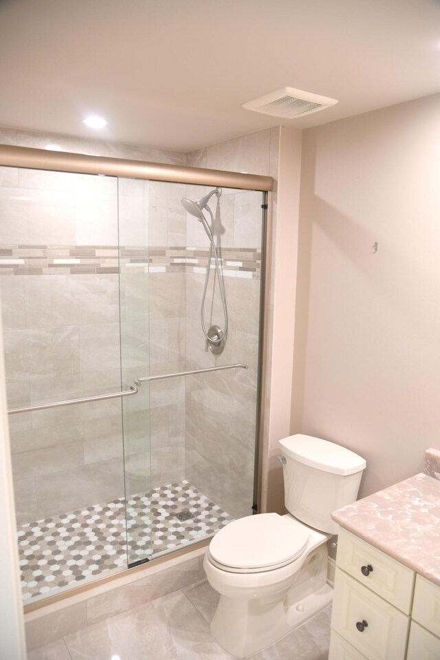 bathroom featuring walk in shower, tile patterned floors, vanity, and toilet