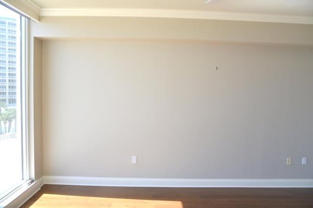 unfurnished room with wood-type flooring and crown molding