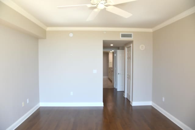 spare room featuring ornamental molding, ceiling fan, and dark wood-type flooring