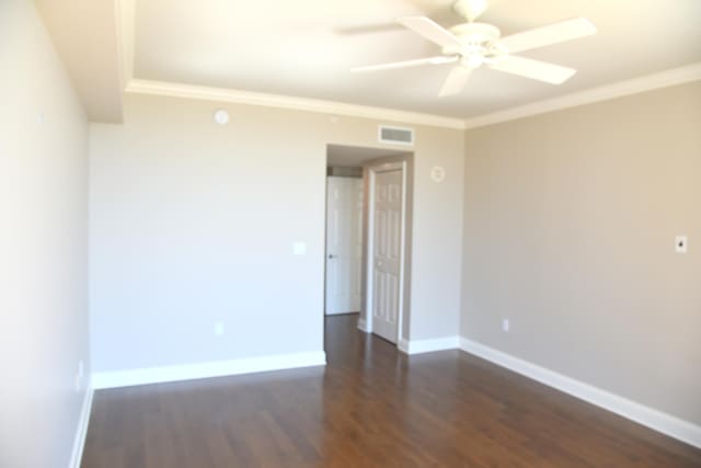 spare room featuring ornamental molding, dark hardwood / wood-style flooring, and ceiling fan