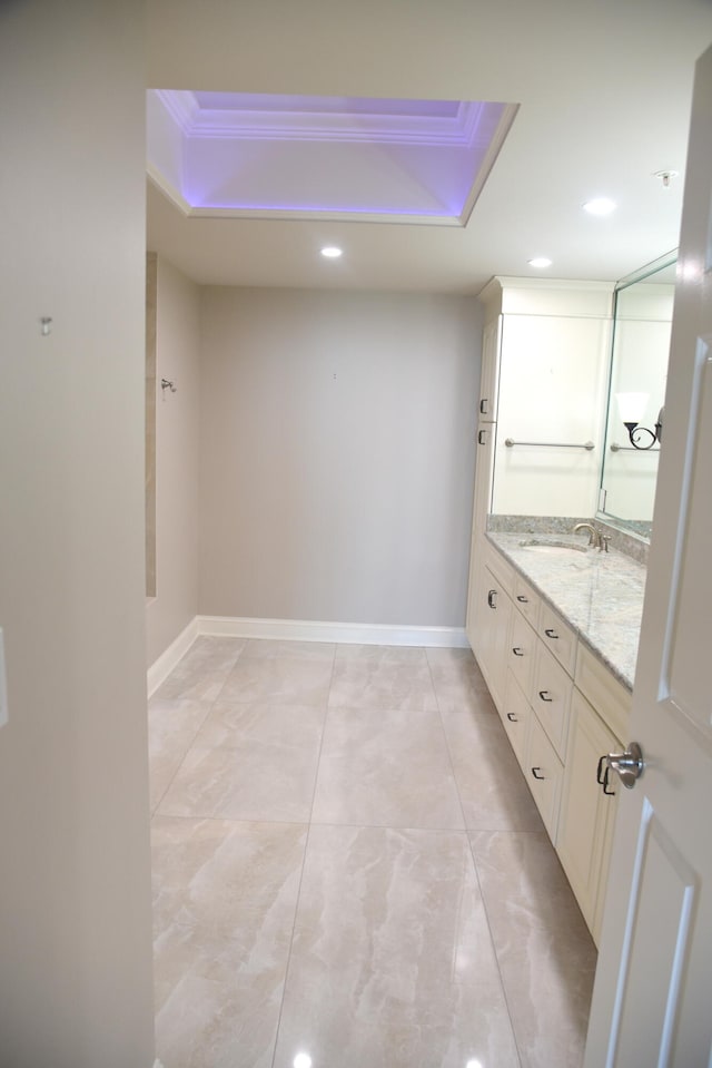 bathroom featuring vanity, a tray ceiling, and crown molding