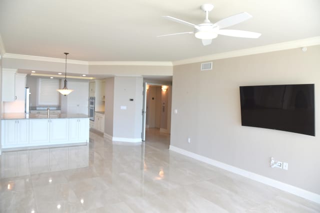 unfurnished living room with ceiling fan and ornamental molding