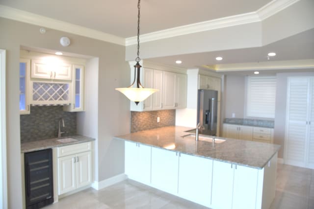 kitchen featuring kitchen peninsula, stainless steel fridge with ice dispenser, hanging light fixtures, and white cabinetry