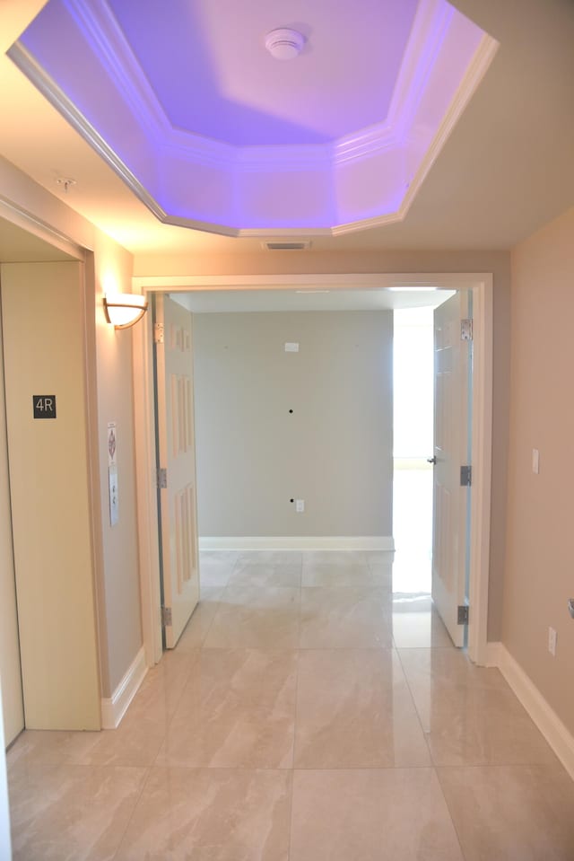 hall featuring ornamental molding and a tray ceiling