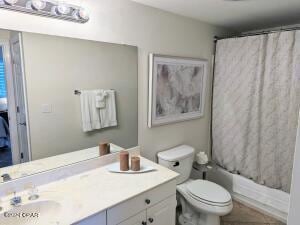 full bathroom featuring shower / bath combo, vanity, and toilet