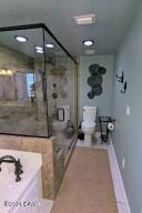 bathroom with walk in shower and toilet