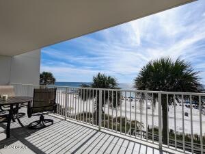 balcony featuring a water view and a beach view