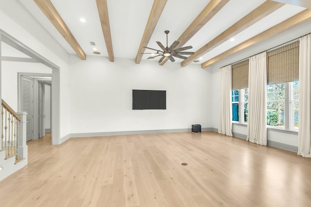 unfurnished living room with light hardwood / wood-style floors, ceiling fan, and beamed ceiling