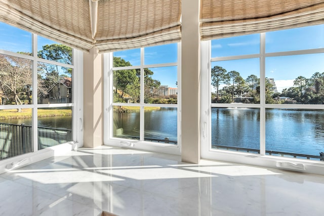 unfurnished sunroom featuring a water view