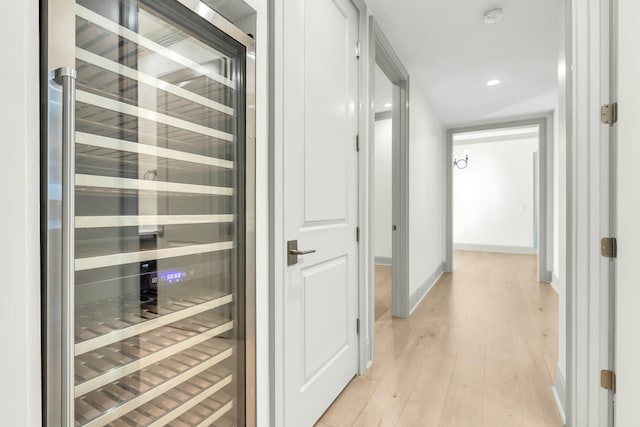 corridor with wine cooler and light hardwood / wood-style floors