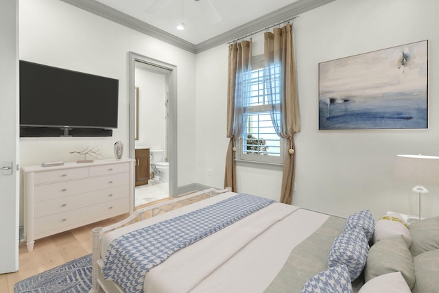 bedroom featuring crown molding, ceiling fan, light hardwood / wood-style flooring, and ensuite bath