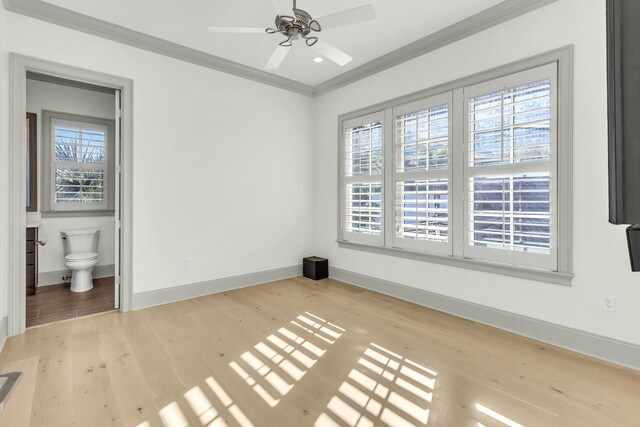 interior space featuring ceiling fan, ornamental molding, light wood-type flooring, and ensuite bathroom